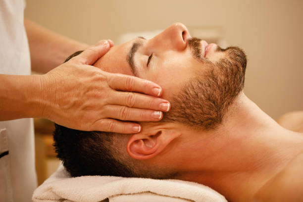 close up of man getting head massage and relaxing with eyes closed at the spa.